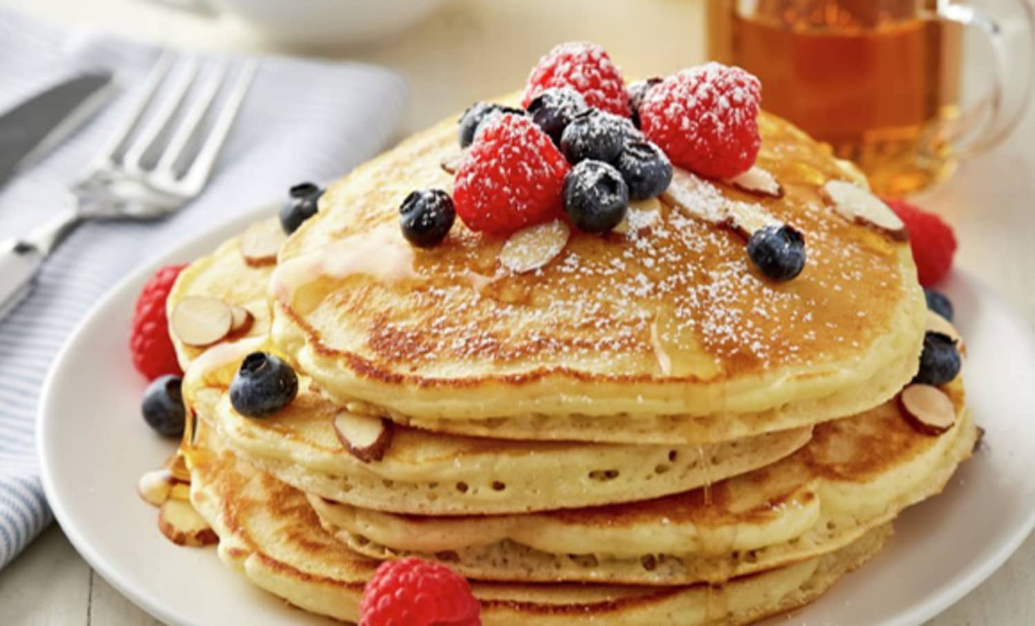 Stack of pancakes, fruit, and almond slivers